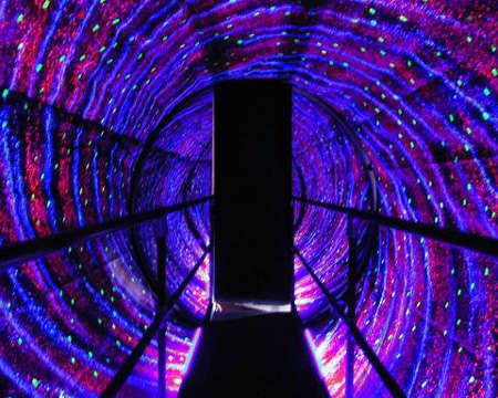 Illuminated LED light tunnel glowing purple and blue as an evening attraction at Rangmanch Farms, an outdoor event venue in Gurugram near Delhi