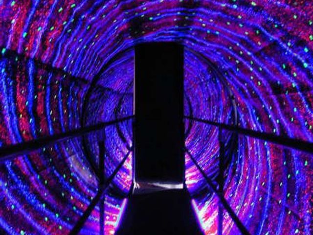 Illuminated LED light tunnel glowing purple and blue as an evening attraction at Rangmanch Farms, an outdoor event venue in Gurugram near Delhi