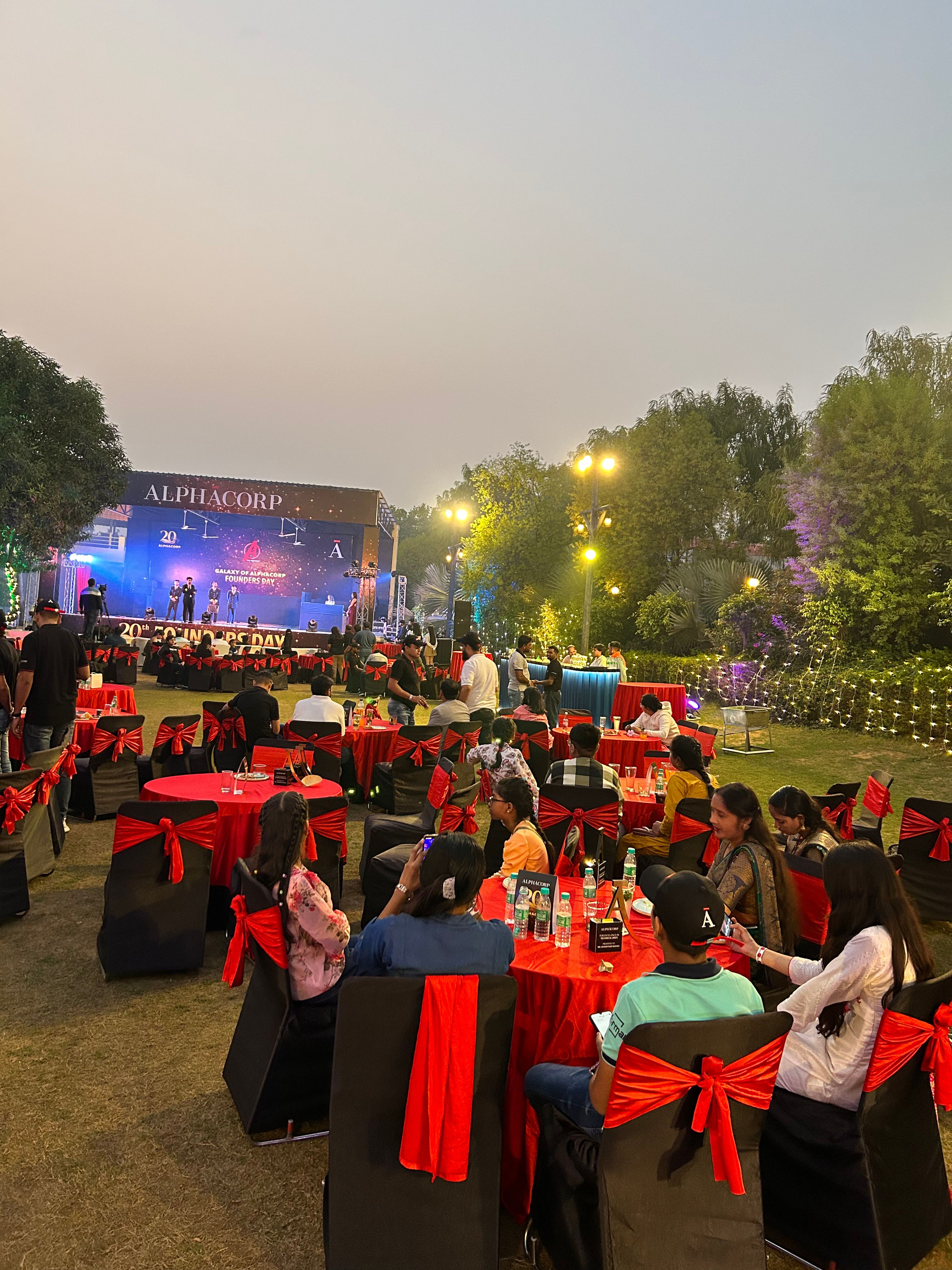 Corporate annual day dinner on the lawn at dusk — corporate event venue near Delhi, Rangmanch Farms, Gurugram