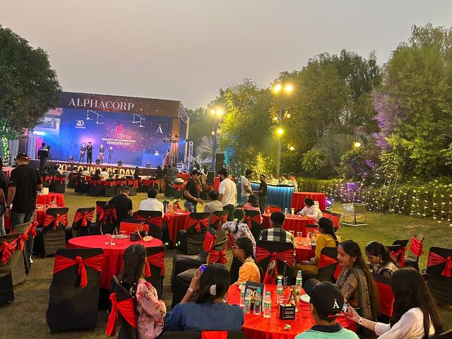 Corporate annual day dinner on the lawn at dusk — corporate event venue near Delhi, Rangmanch Farms, Gurugram