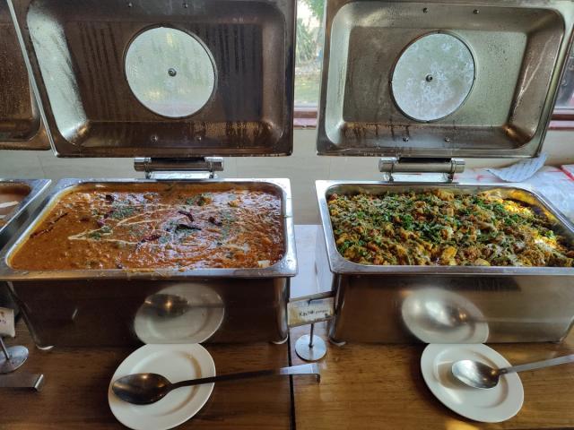 Curries on the main course counter of the buffet lunch — vegetarian corporate catering at Rangmanch Farms, Gurugram