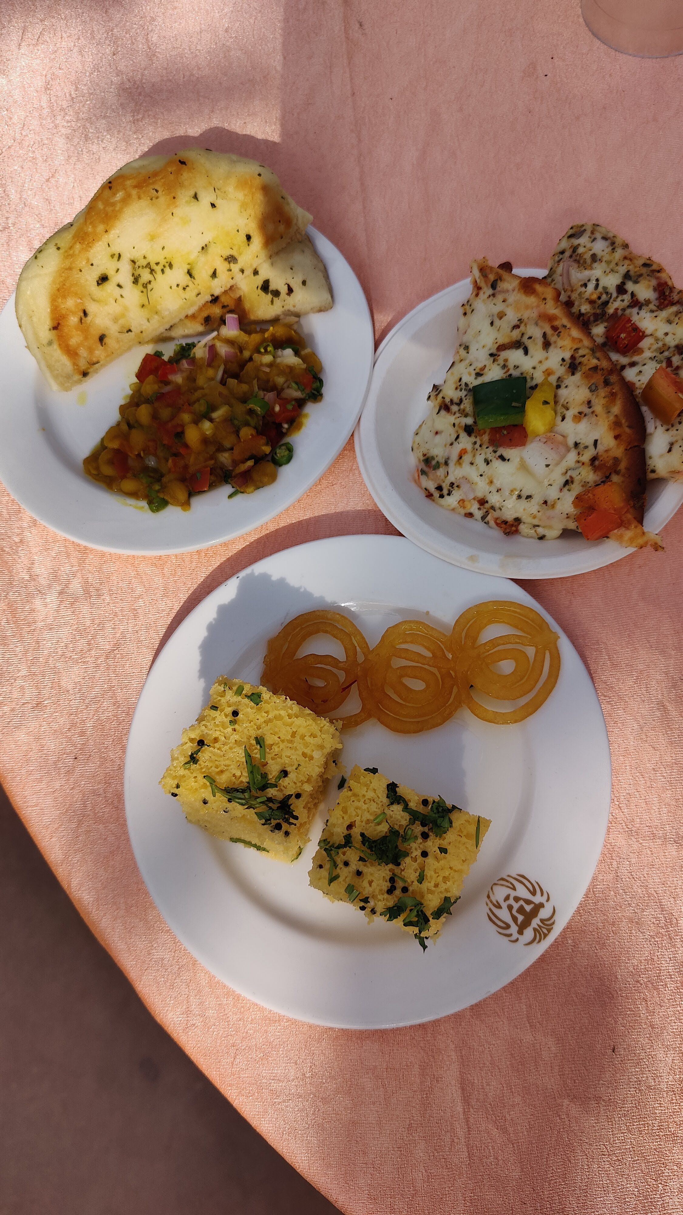 Plates of starters, pizza and desserts including jalebi served on a table during an event at Rangmanch Farms, an outing venue in Gurugram near Delhi