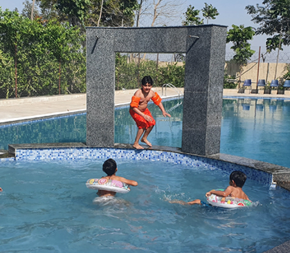 Guests in the swimming pool at Rangmanch Farms