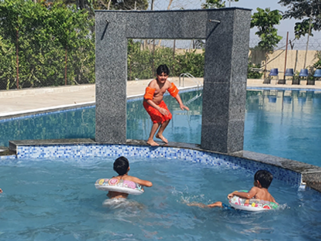 Guests in the swimming pool at Rangmanch Farms