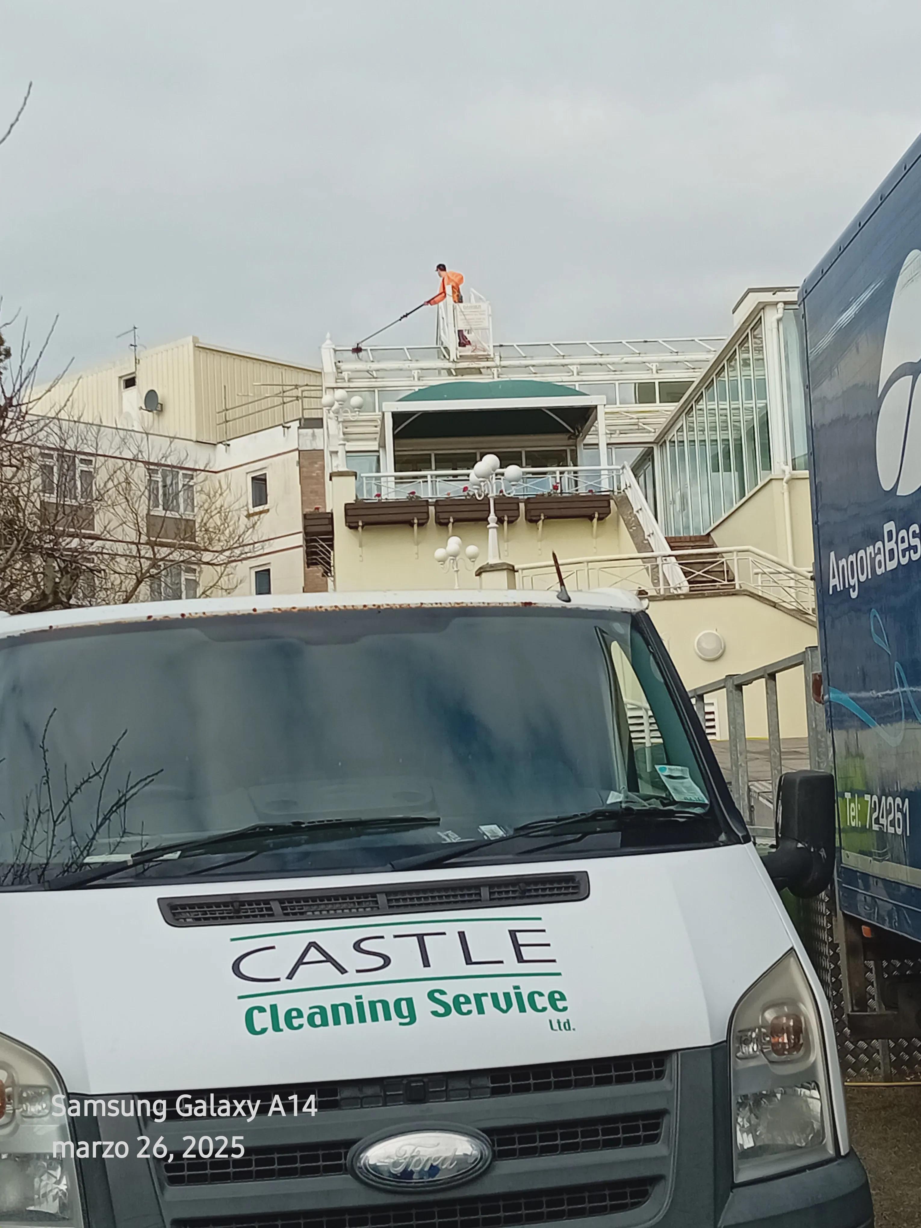 Castle cleaning van parked with cleaner on roof above