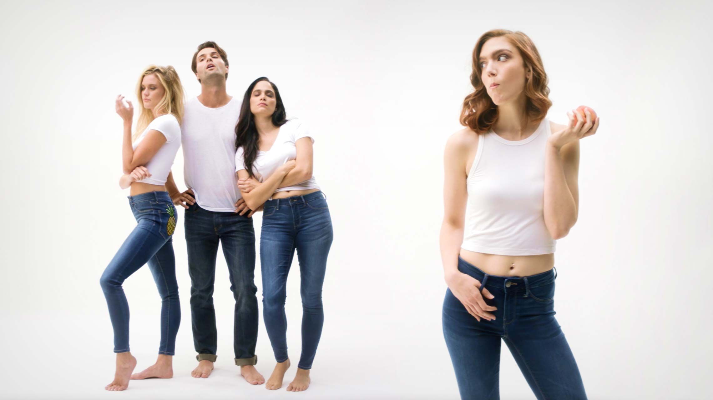 Photograph of models posing in jeans and eating fruit. Click to view one of the television advertisements.