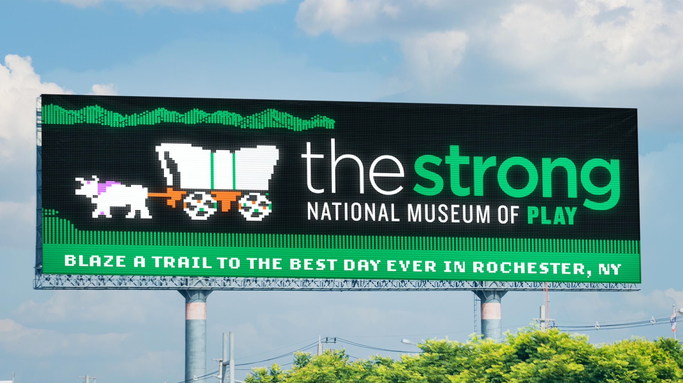 Billboard for The Strong National Museum of Play that looks like the early 1990s computer game Oregon Trail.