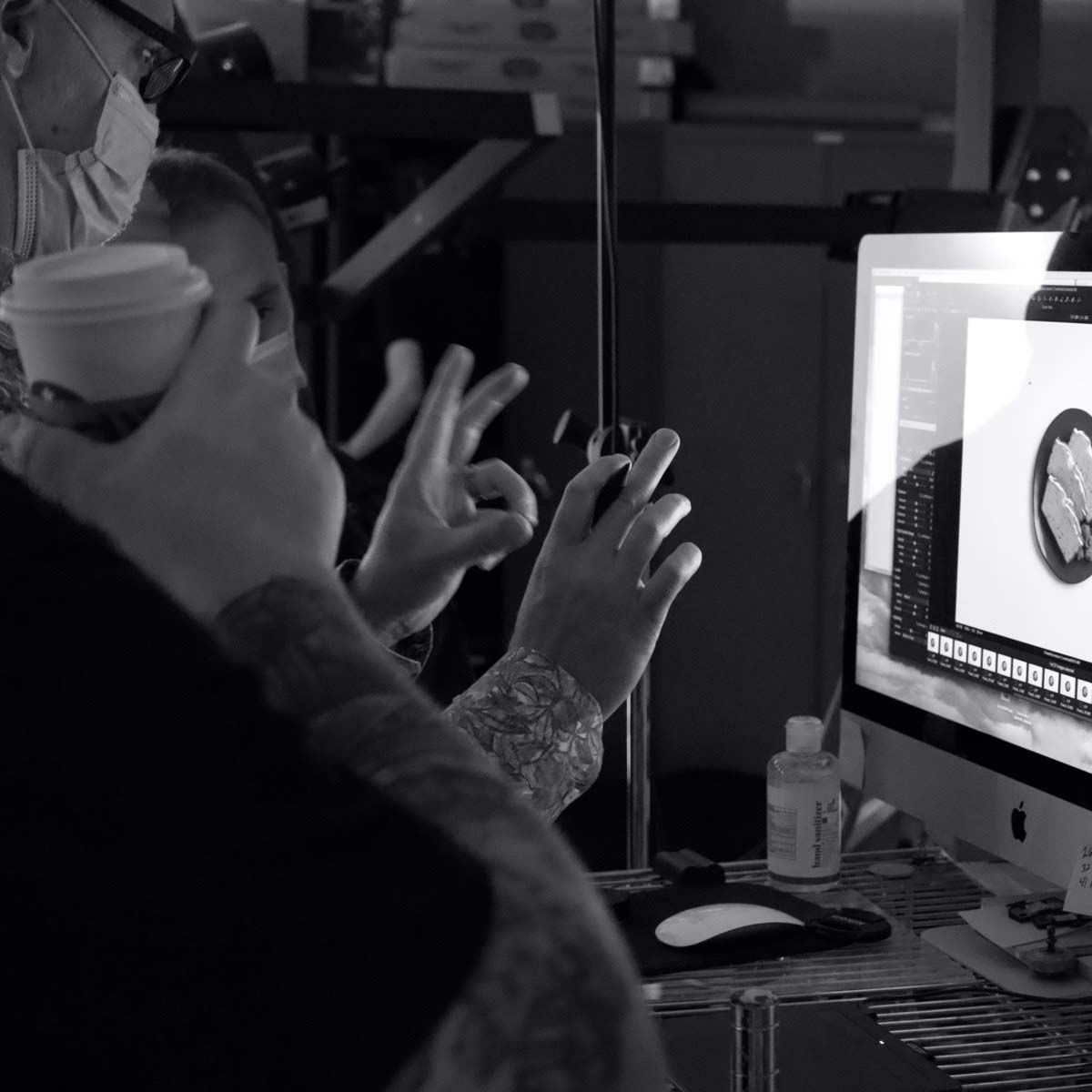 Photograph of two P+N employees looking at product photography on a monitor.