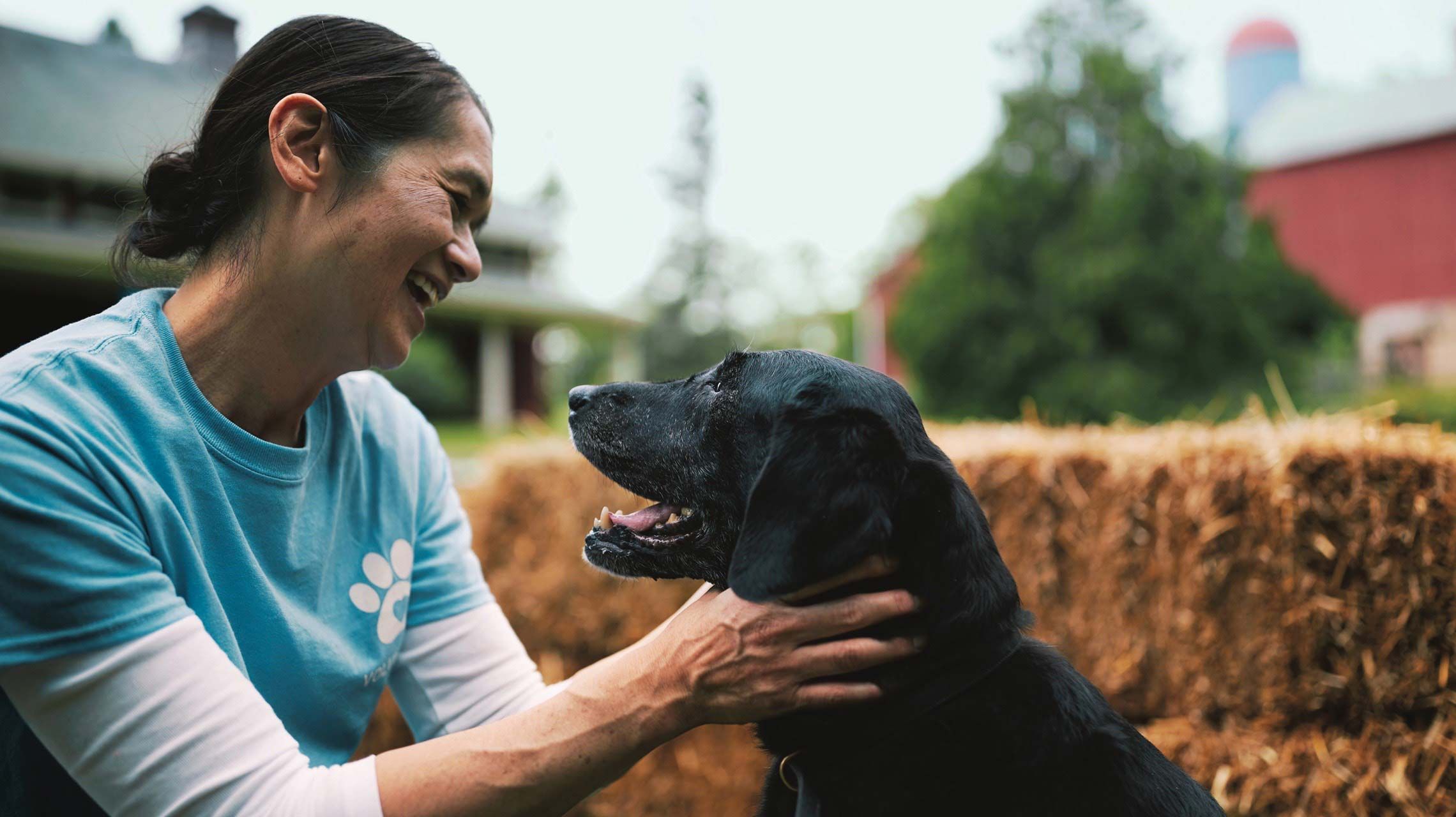 Photograph of a woman petting a dog.