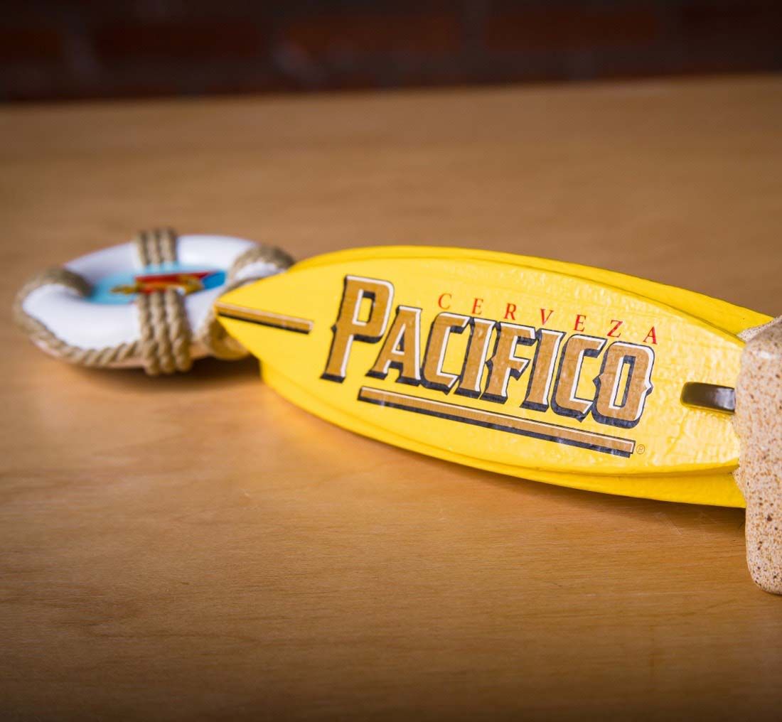 Photograph of a Pacifico bottle opener shaped like a surfboard.