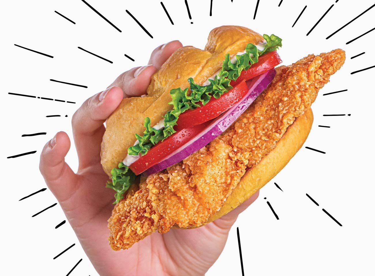 A hand holding a crispy chicken sandwich from Smashburger.