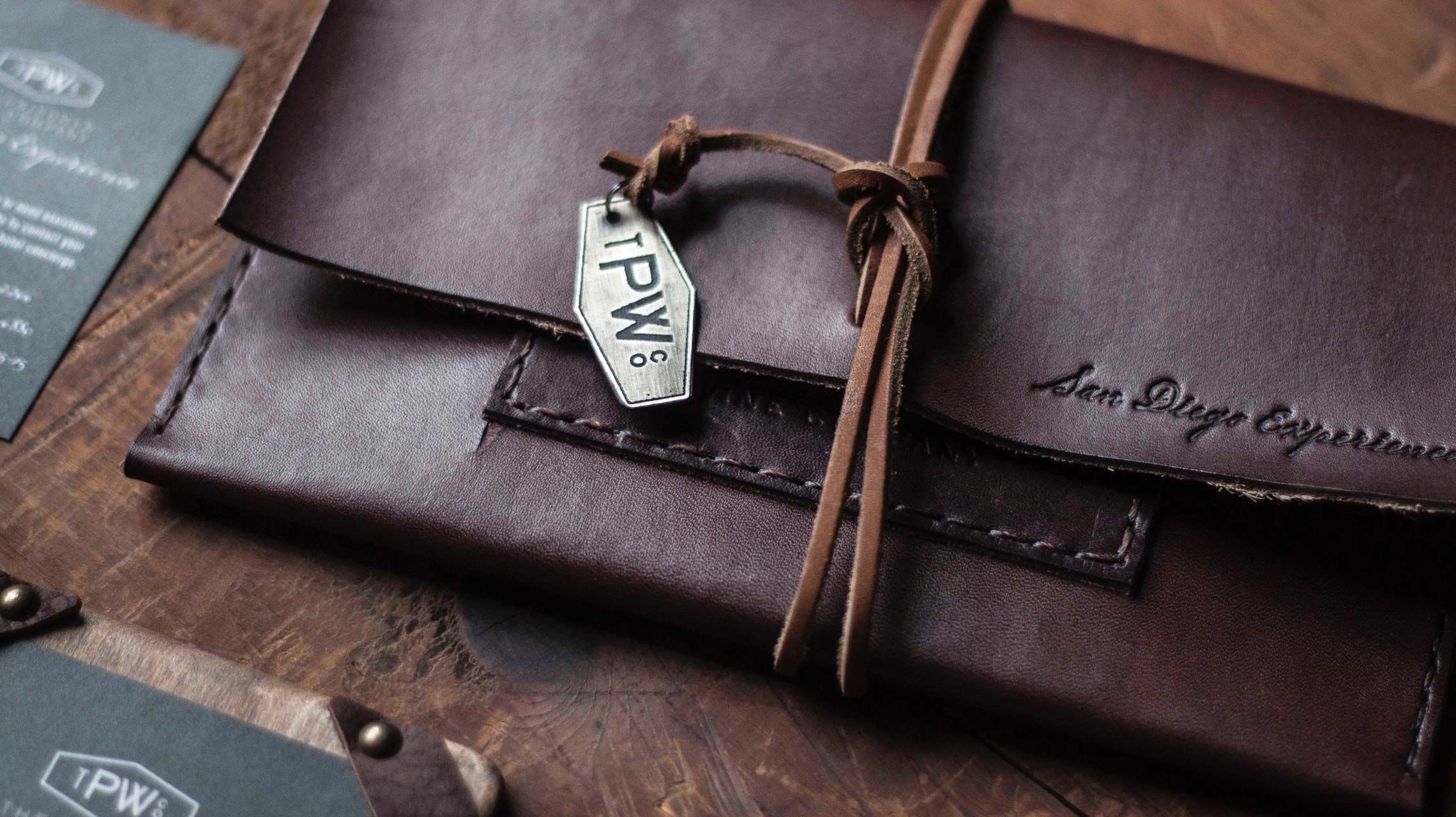 Photograph of event collateral, featuring a leather packet and a metal tag.