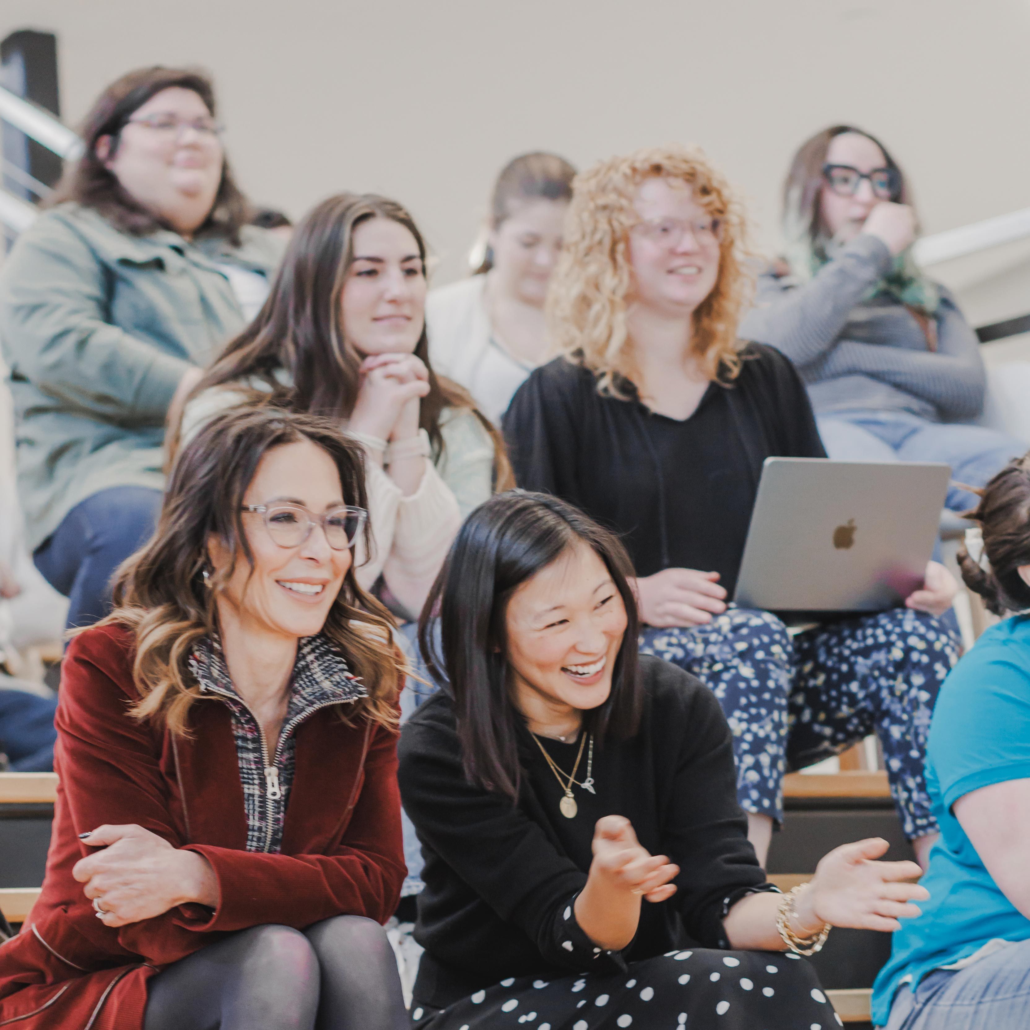 Photograph of employees laughing during a meeting.