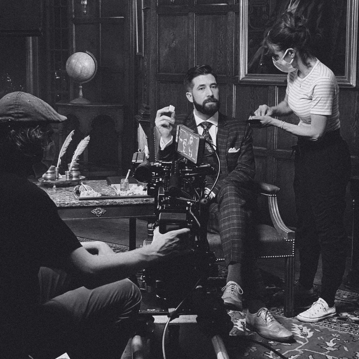 Photograph of a makeup artist getting an actor ready for a shoot.