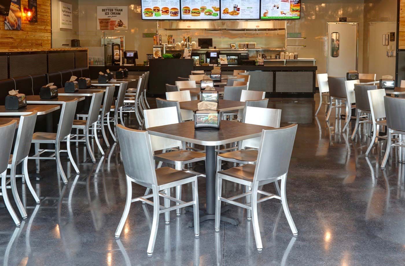 Photograph of a BurgerFi interior, showing all the tables where people can sit.