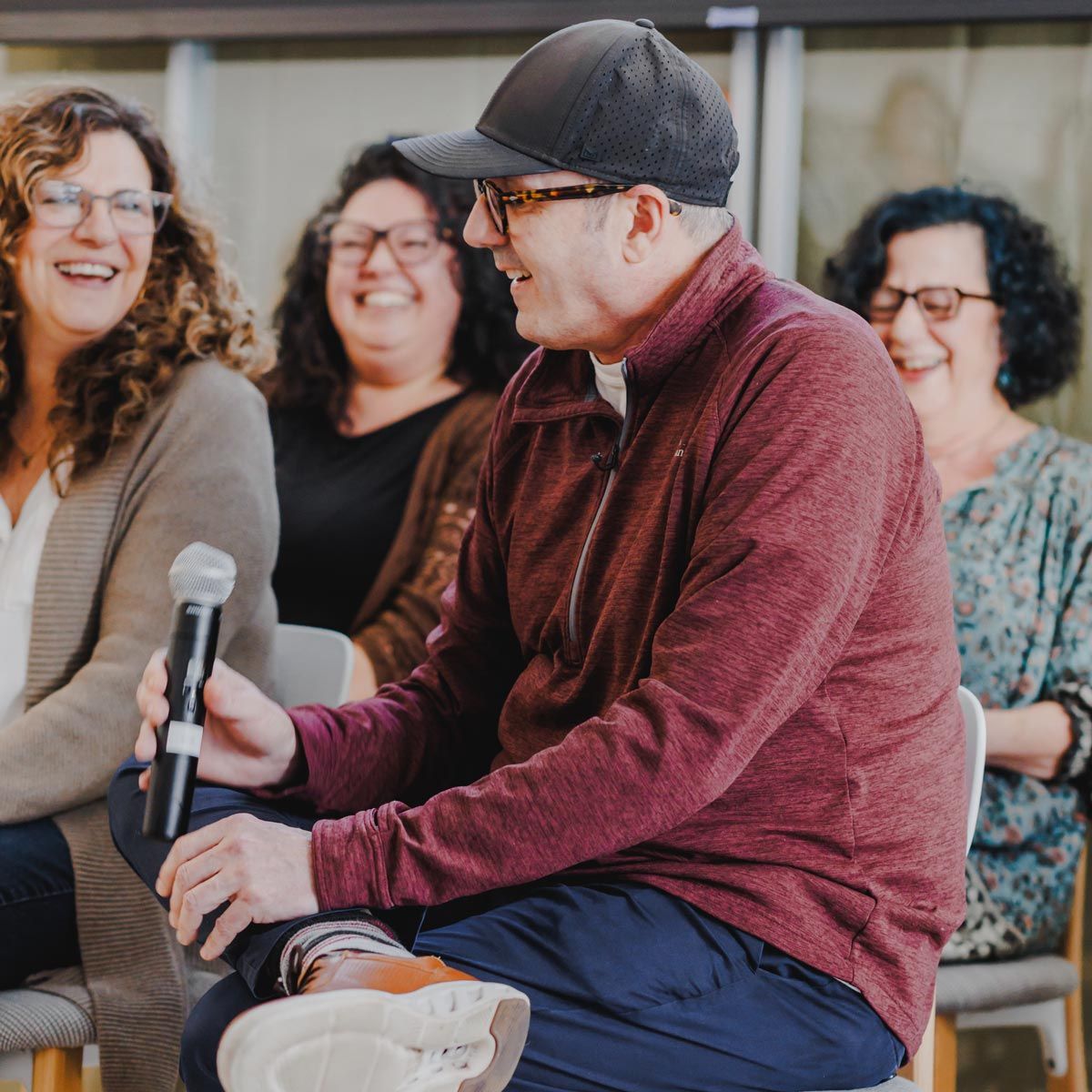 Photograph of employees laughing during a speaking engagement.