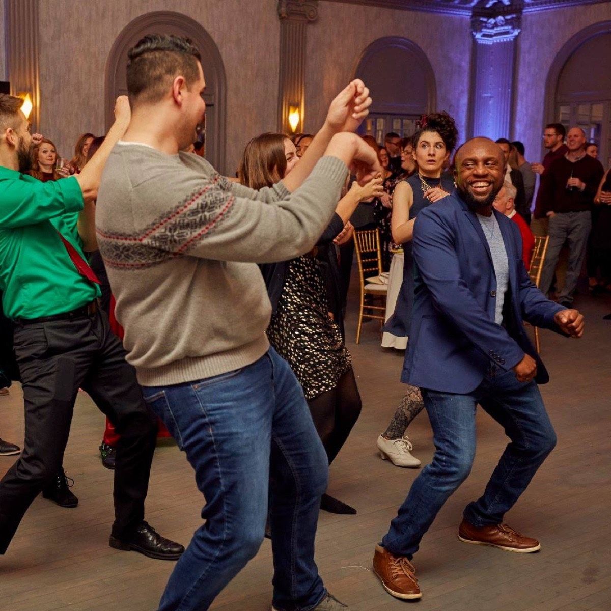 Photograph of employees dancing and smiling at a holiday party.