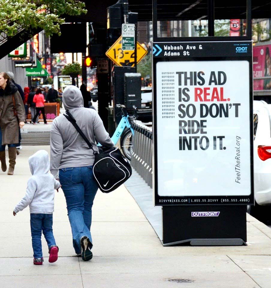 Bike rental stop ad - "This ad is real, so don't ride into it."