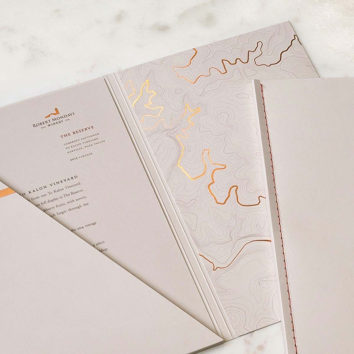 Close-up photograph of the embossed Robert Mondavi Winery map and other collateral pieces.