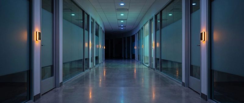 A hand held to a glowing biometric access panel beside a secure door