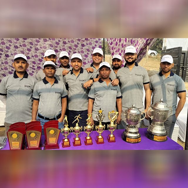 The Inspira sports team with the trophies and cups won at an inter-company tournament