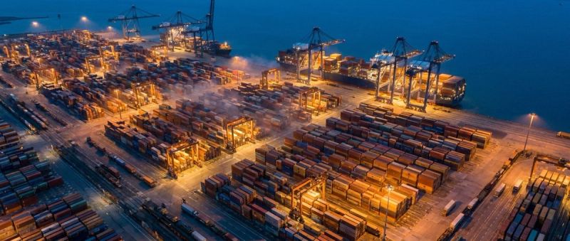 An aerial view of a container port and logistics terminal at blue hour