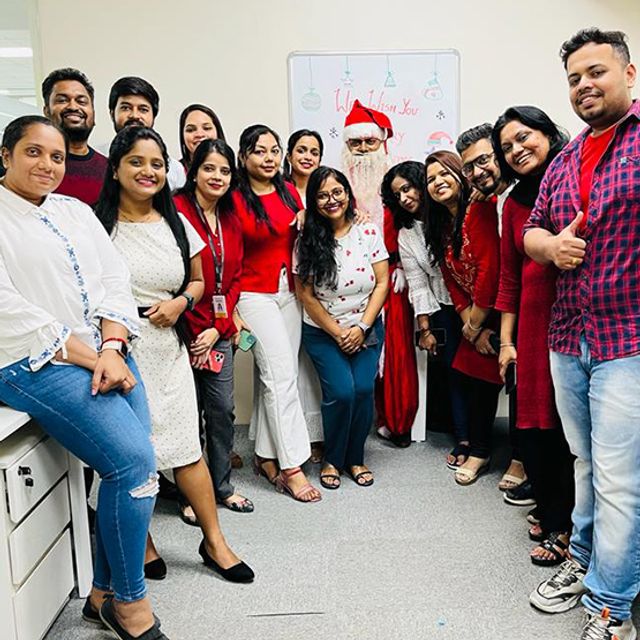 Inspira colleagues in red at a Christmas celebration in the office