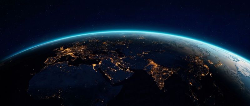 Earth at night from orbit, city lights tracing the continents