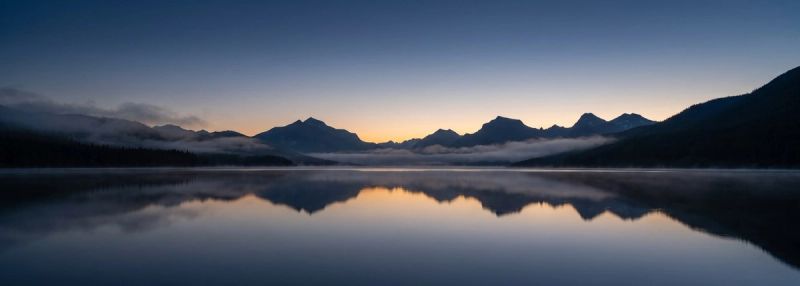 First light breaking over a still mountain lake