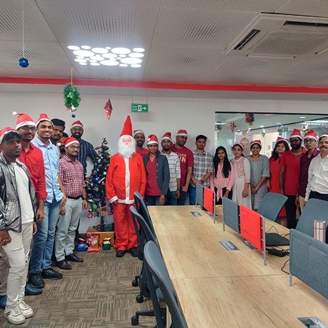 A large team gathered around the Christmas tree at the Inspira office party