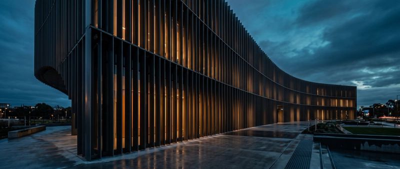 A classical institutional colonnade lit at blue hour