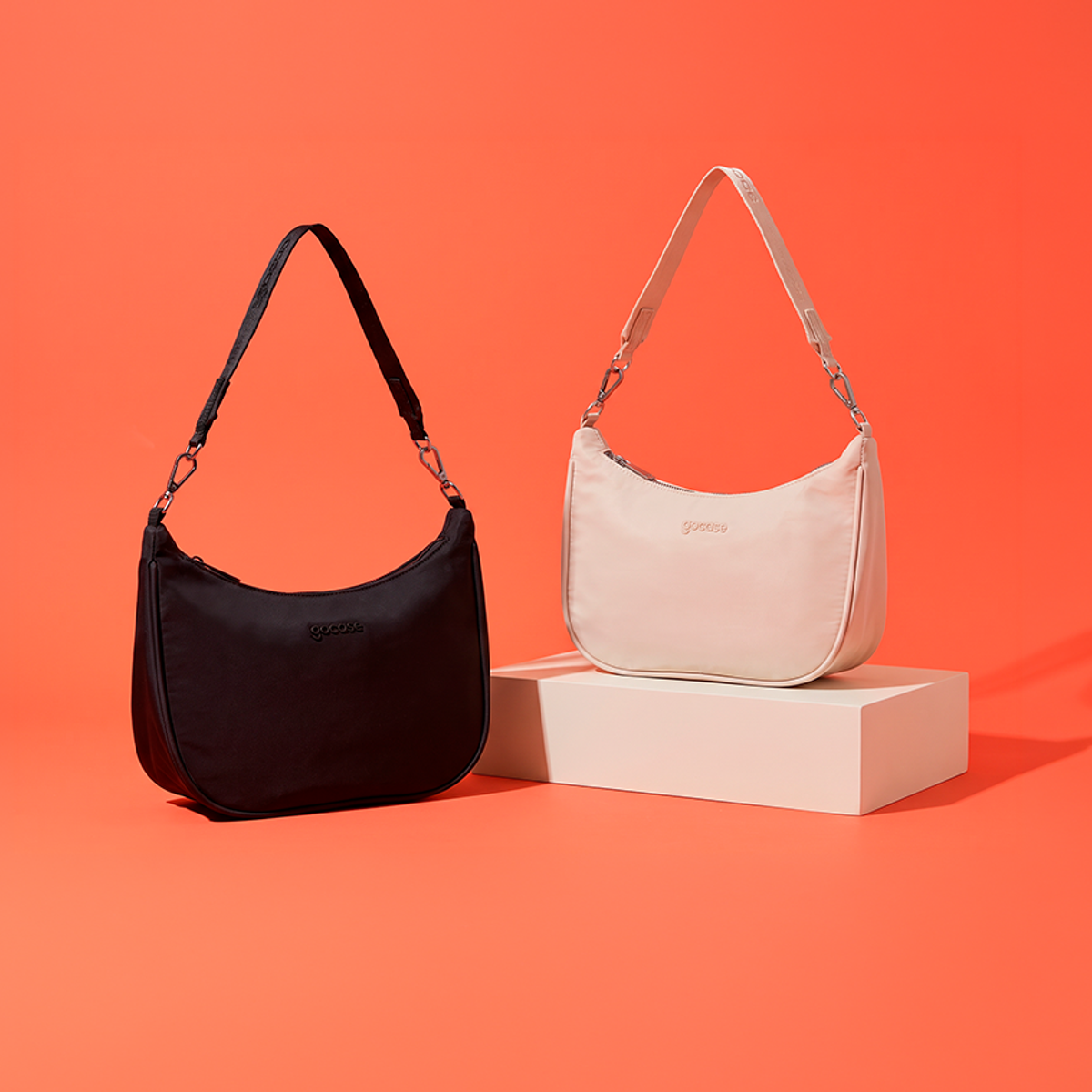 Bolsa Essentials Pro preta e off-white em cenário coral