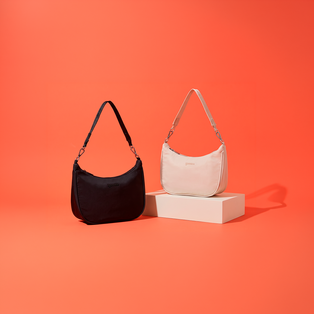 Bolsa Essentials Pro preta e off-white em cenário coral