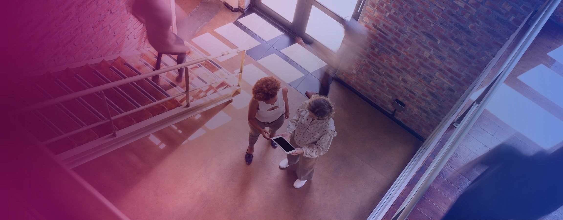 Office stock image, with people conversing at the bottom of a staircase