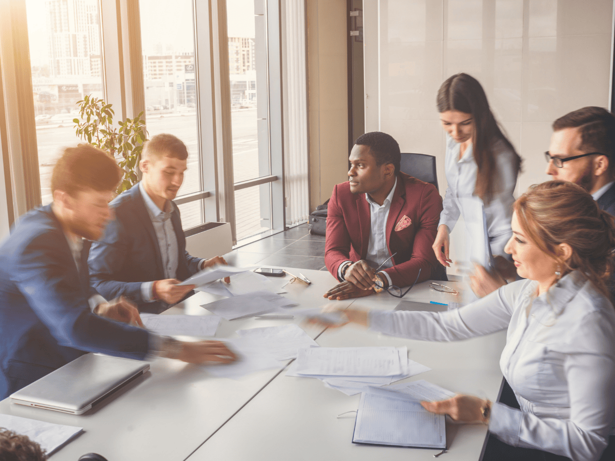 Ihmisiä kokouspöydän ääressä