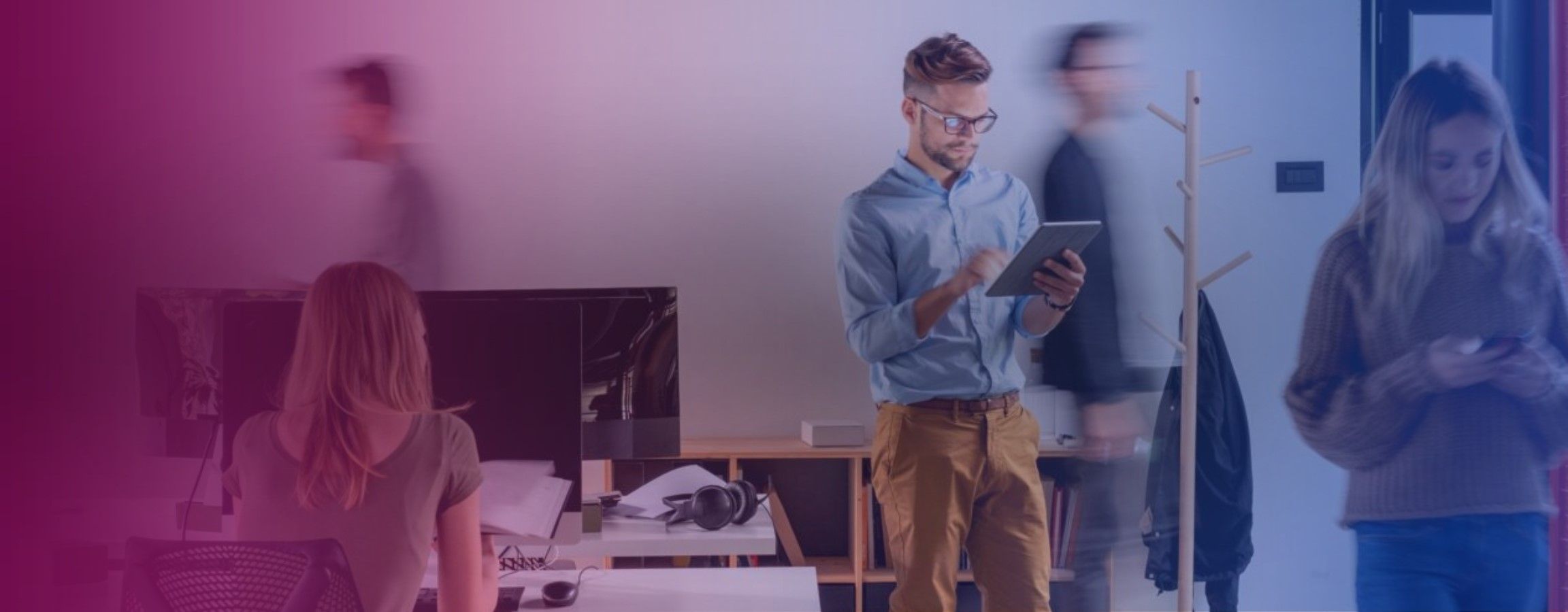 Office stock image with an employee looking at work on their tablet