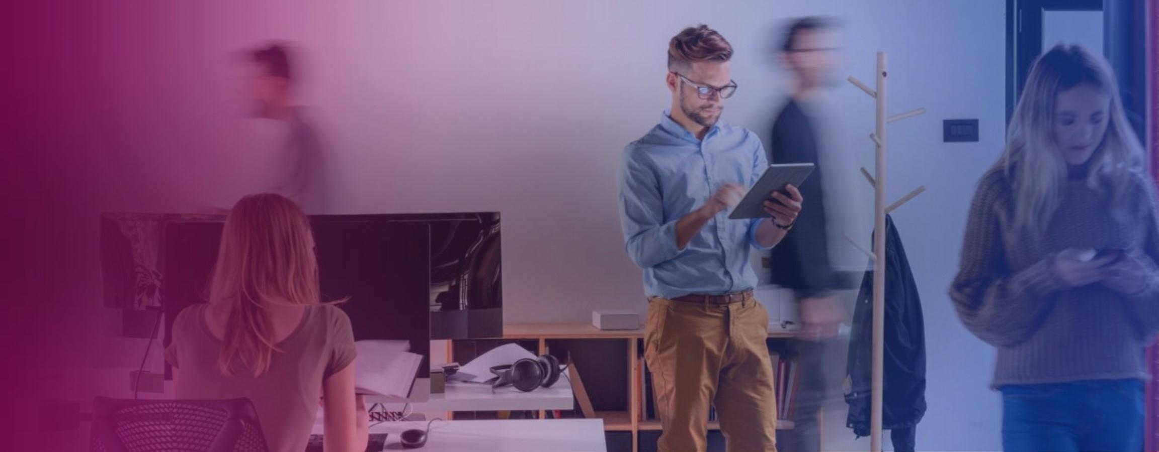 Office stock image with an employee looking at work on their tablet