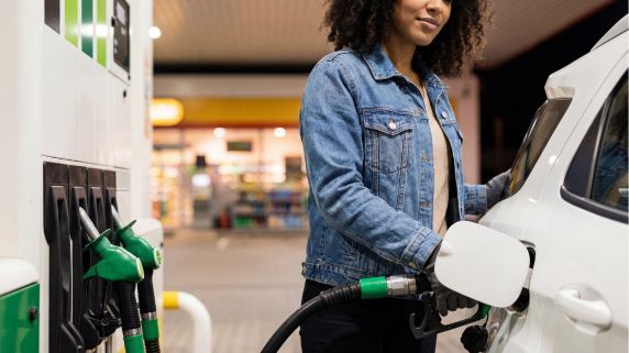 person filling up their car with fuel