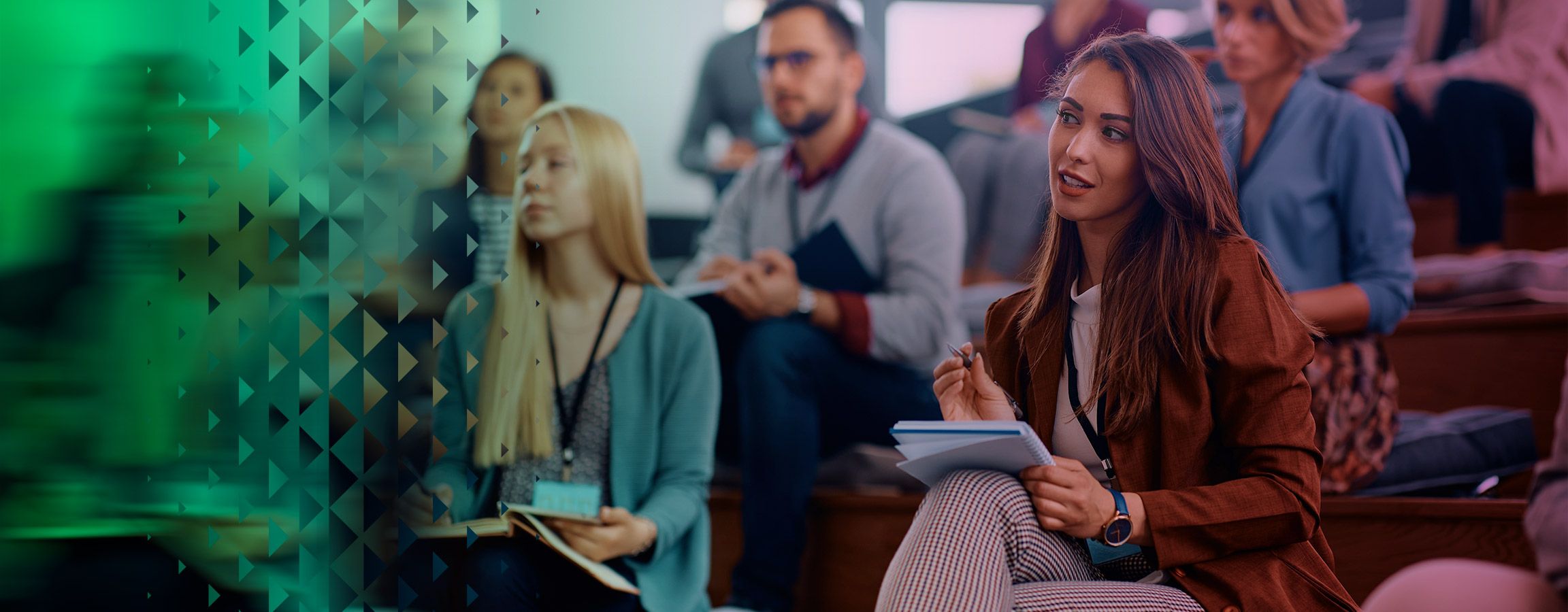 People in an auditorium taking notes