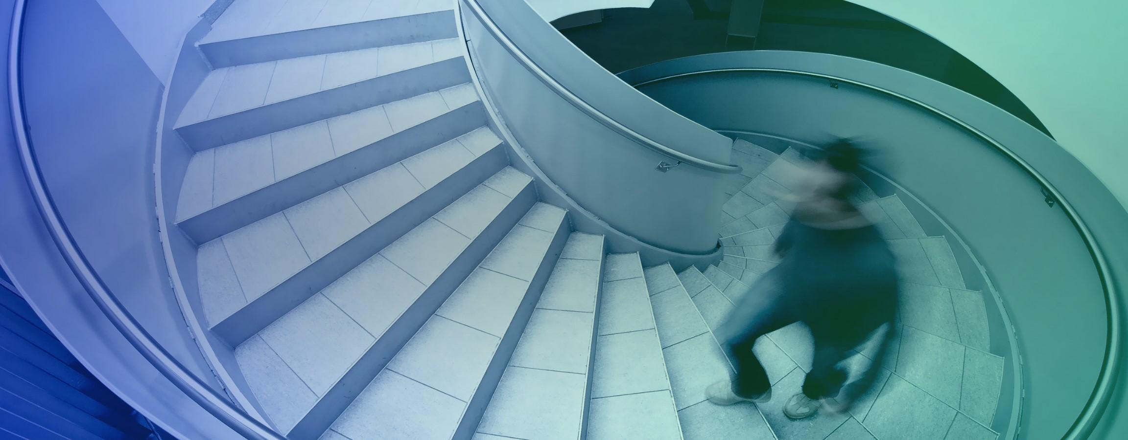 A person walking up a spiral staircase