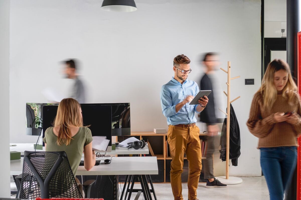 Man on a tablet in a busy office