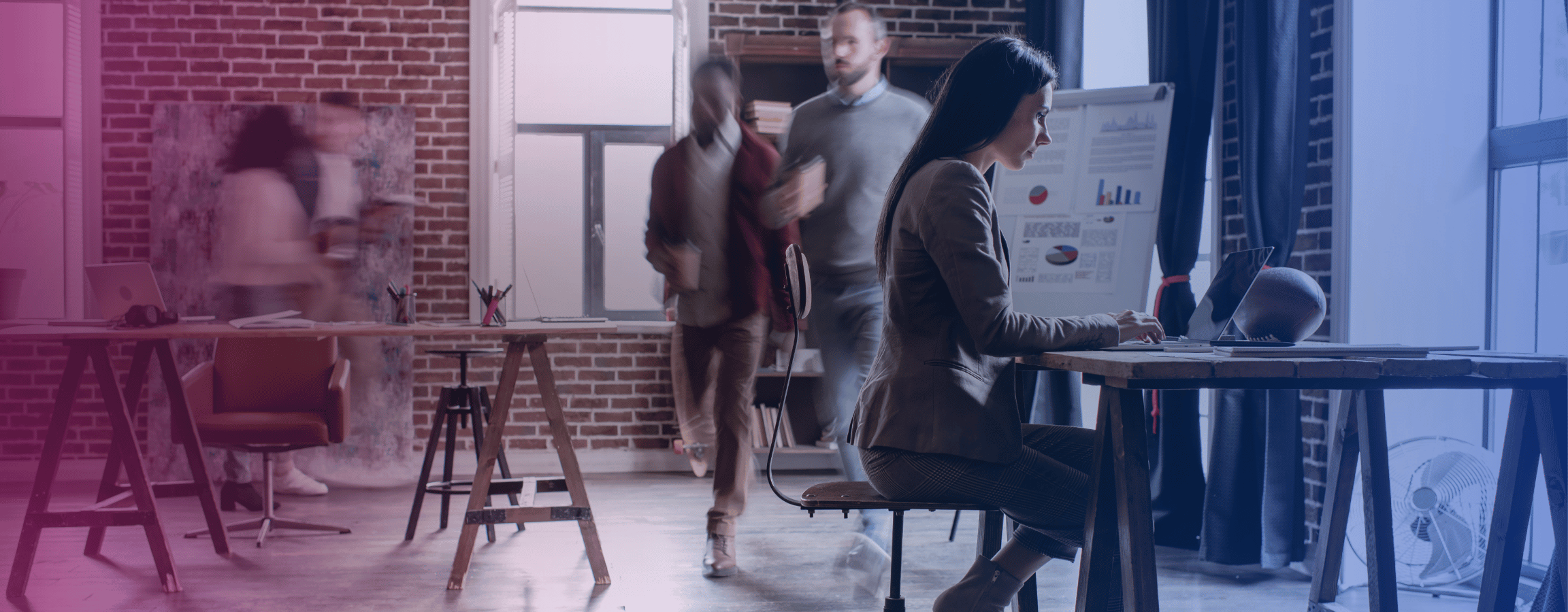 ihmisiä tiiliseinäisellä toimistolla