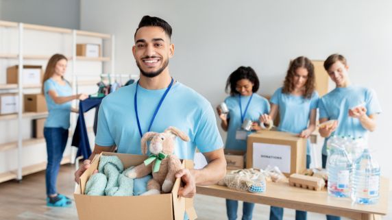 Stock image of volunteers sorting through donations for a charity