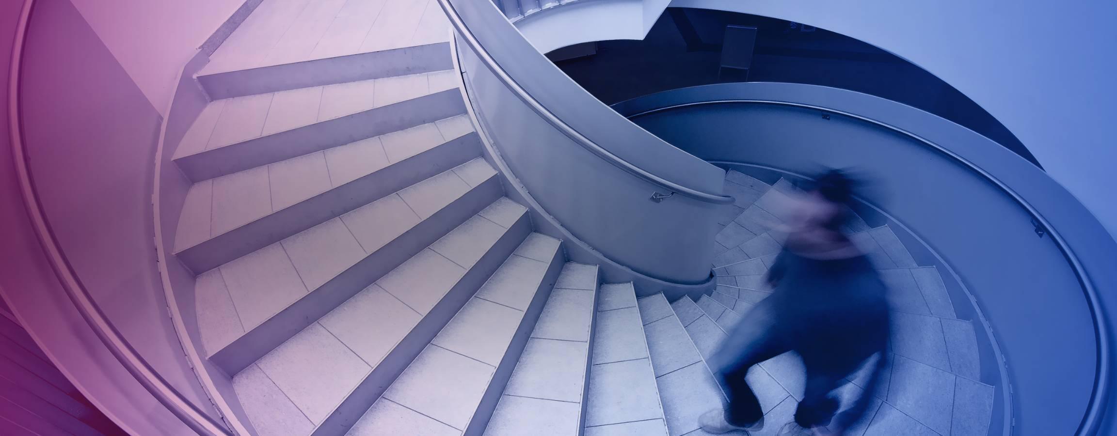 Mand, der går op ad en vindeltrappe