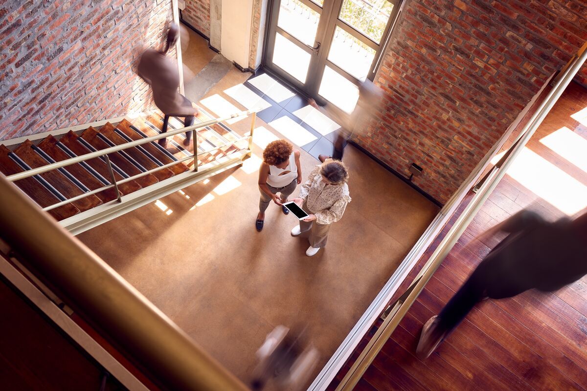 Two people talking on stairs in an office