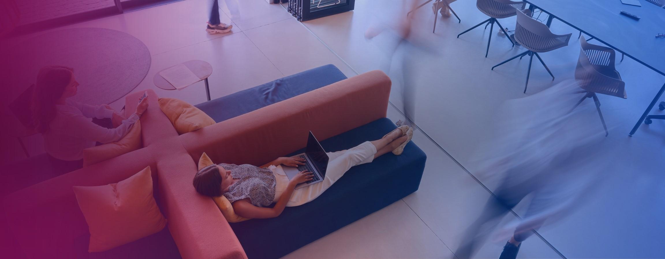 Stock image of people working on their laptops on sofas
