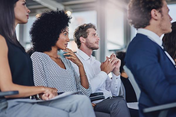 People in a room, listening to a presenter