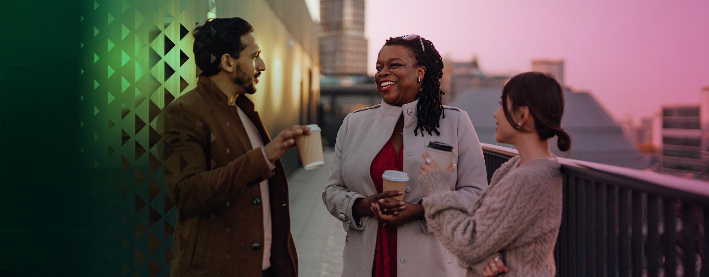 Kolme hymyilevää ihmistä keskustelee