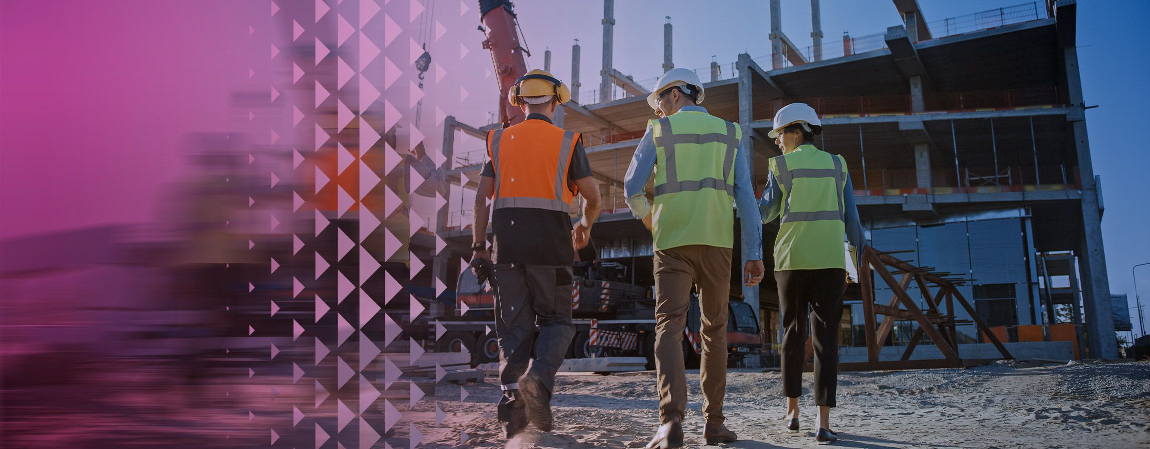 Kolme ihmistä rakennustyömaalla kypärät päässä