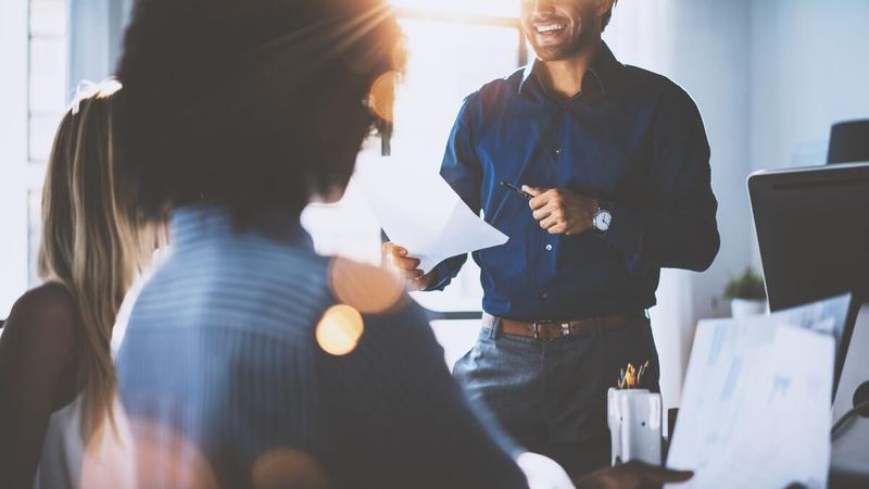 Smiling people around a desk